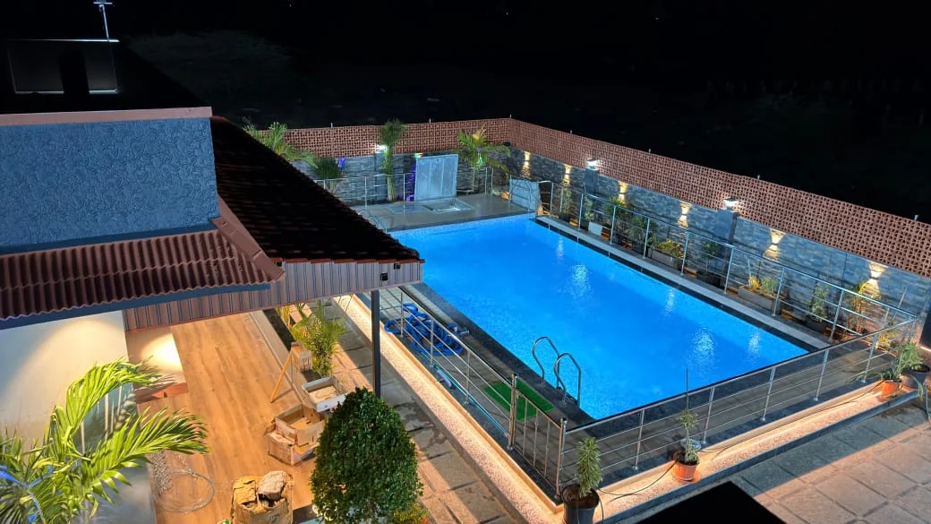 Actual swimming pool at AVULA’S RESORTS illuminated at night